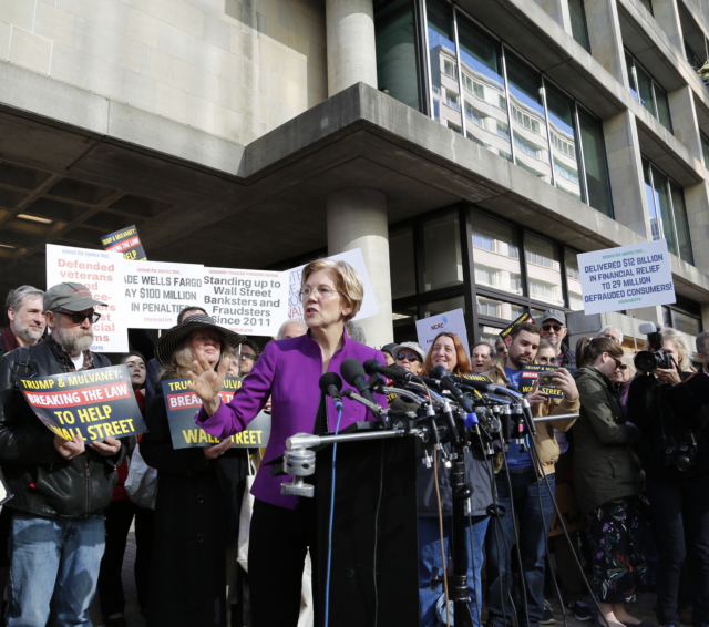 Elizabeth Warren speaking from a podium at a rally for the CFPB
