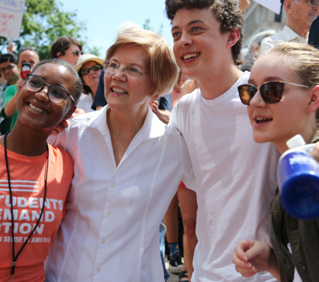 Elizabeth Warren posing with students at the Family Reunification rally