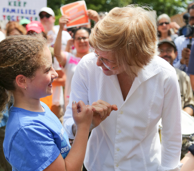 Elizabeth Warren pinky swearing with a young girl